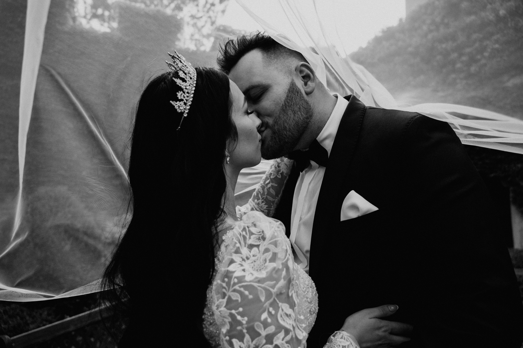 Couple kissing under a wedding veil
